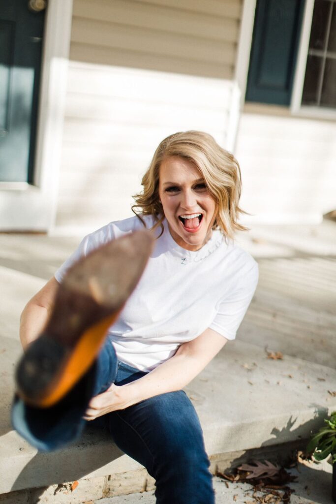 blonde girl in white t shirt with foot extended towards the camera